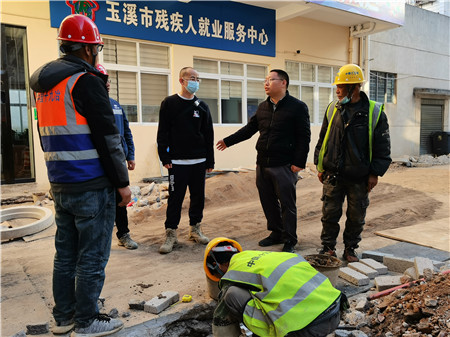 在老旧小区改造现场,邹著(右二)与施工单位人员交流。