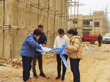 在地质灾害搬迁点,李星瑶(左三)和同事查看施工情况。_副本