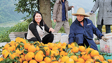 彭永芳(左一)向村民刀云安了解今年柑橘种植情况。