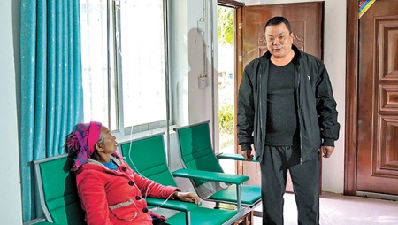 赵建文(右一)在村卫生室了解村民就医情况。