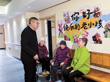 代宝盛(左一)向入住李棋街道综合养老服务中心的老人们了解起居情况。